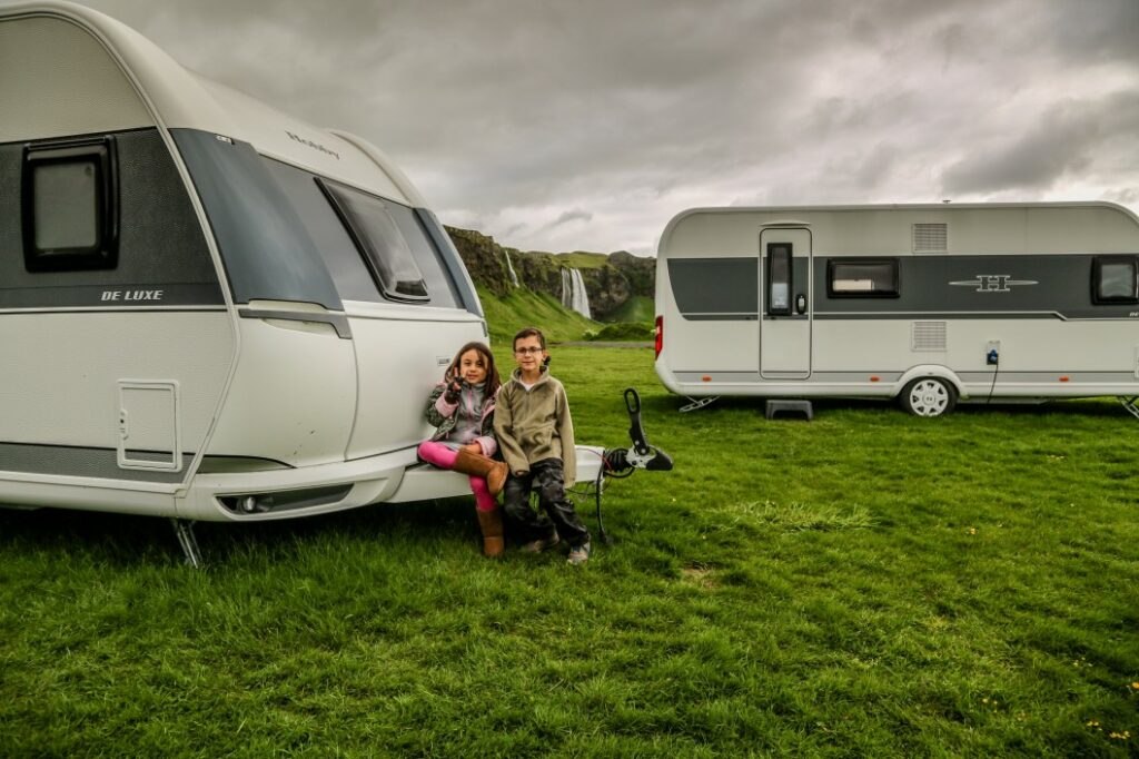 kids sitting outside rv on cloudy day - homeschooling on the road