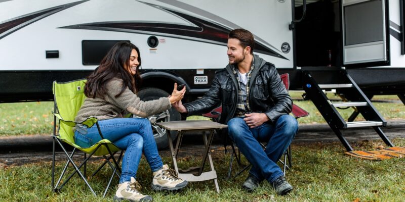 Two people outside of a camper van